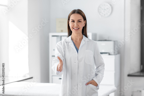 medicine  healthcare and profession concept - smiling female doctor giving her hand for handshake at hospital