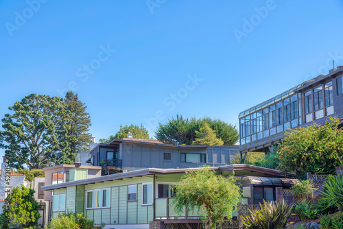 Large houses surrounded by trees against the sky background in San Francisco, CA © Jason