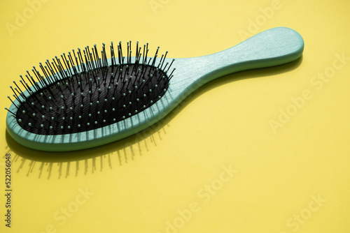 Green comb on the yellow background  empty space for text