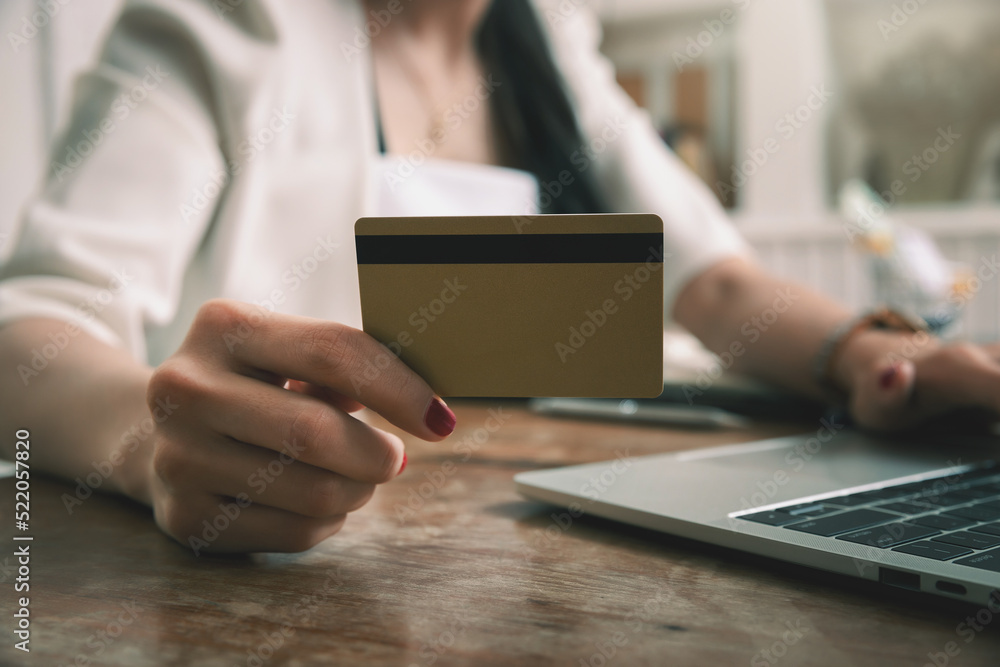 Businesswoman holding credit card and using laptop. Making payment while online shopping. E-commerce and modern technology concept. Businesswoman holding credit card and using laptop. Making payment while online shopping. E-commerce and modern technology concept.