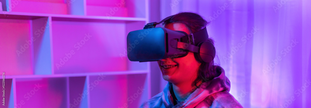 Man wears virtual reality glasses and uses joystick to play games with fun, Male in glasses of virtual reality, VR, Future games, Gadgets, Technology, Red and blue background, VR game concept. Man wears virtual reality glasses and uses joystick to play games with fun, Male in glasses of virtual reality, VR, Future games, Gadgets, Technology, Red and blue background, VR game concept.