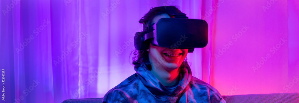 Man wears virtual reality glasses and uses joystick to play games with fun, Male in glasses of virtual reality, VR, Future games, Gadgets, Technology, Red and blue background, VR game concept. Man wears virtual reality glasses and uses joystick to play games with fun, Male in glasses of virtual reality, VR, Future games, Gadgets, Technology, Red and blue background, VR game concept.