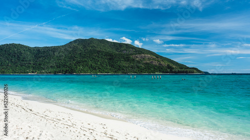 Scenic view of Sunrise Beach, Koh Lipe Island. White sand beach tropical island with crystal clear turquoise sea water against summer blue sky and Koh Adang Island background. Satun, Thailand.