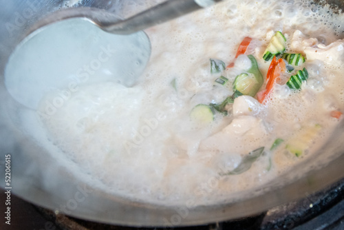 Close-up of Thai cooking looking directly into a steaming wok