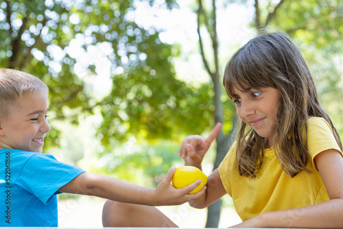 little boy gives fresh lemon to girl in the garden