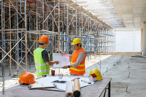 Construction concept of Engineer and Architect working at Construction Site with blue print