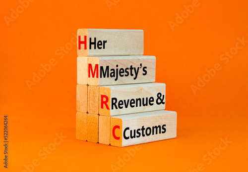 HMRC her majestys revenue and customs symbol. Concept words HMRC her majestys revenue and customs on blocks on beautiful orange background. Business HMRC revenue and customs concept. Copy space. photo