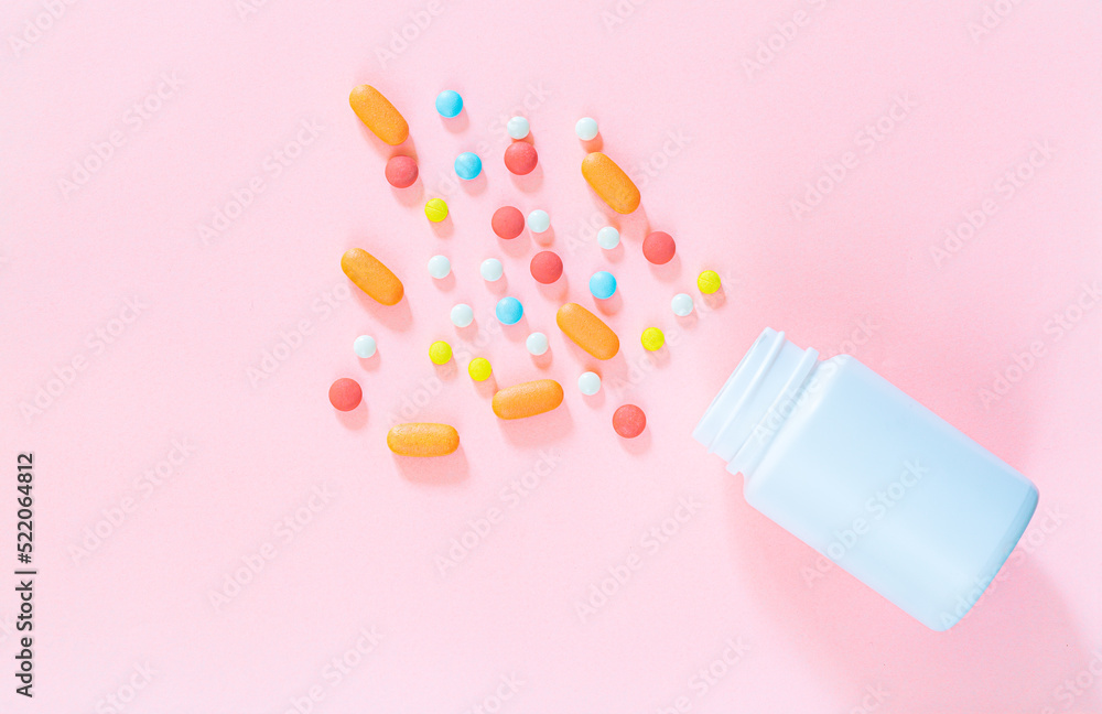 pills and pill bottles on pink background,White pills with selective focus and brown glass bottle on pink background. Antibiotic tablets of the epidemic on neutral backdrop with empty space for image pills and pill bottles on pink background,White pills with selective focus and brown glass bottle on pink background. Antibiotic tablets of the epidemic on neutral backdrop with empty space for image