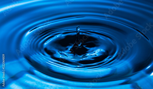 Macro water drop,The water droplets fall on the water surface until the water spread out, creating beautiful ripples on the light blue water
