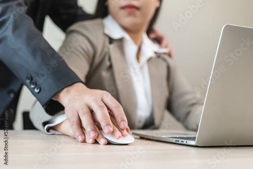 Sexual harassment in the workplace, female employees feel afraid after being touched her hand by manager during work in the office. photo