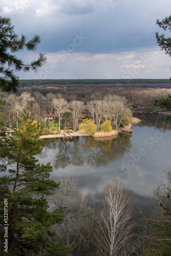 Spring sunny river bank recreation area with rainy clouds. Cossack mountain (Gomilshanski forest, Koropove village) on Siverskyi Donets River in Ukraine photo