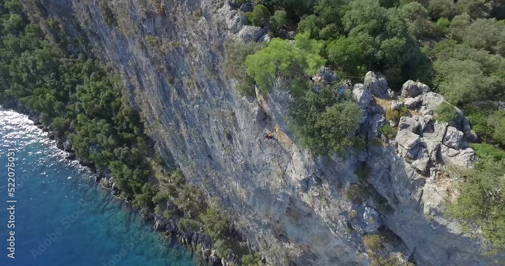 Rock climbing near sea. Climbing to the rock. drone shot Rock climbing near sea. Climbing to the rock. drone shot