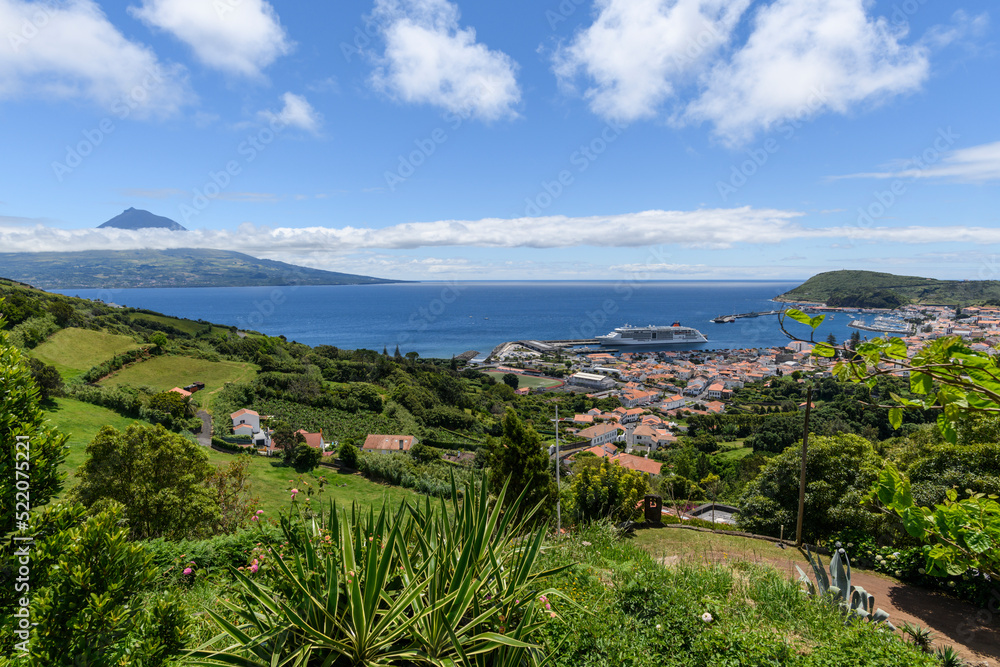 View over Horta to the Pico volcano / View over the town of Horta on the island of Faial, a cruise ship is moored in the harbor, on the horizon you can see the Pico volcano, Azores, Portugal.