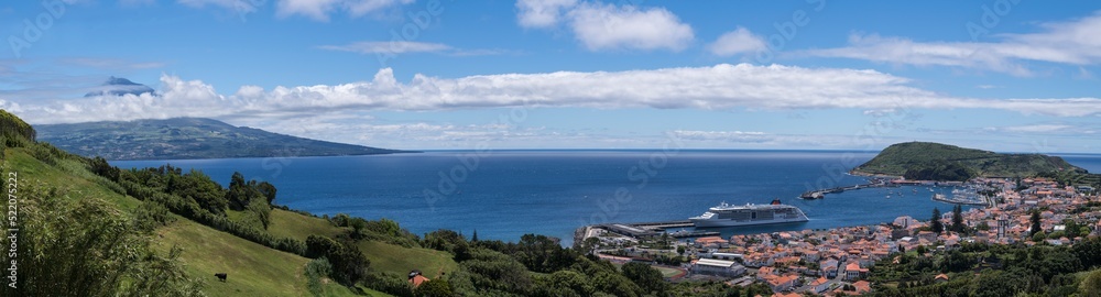 View over Horta to the Pico volcano / View over the town of Horta on the island of Faial, a cruise ship is moored in the harbor, on the horizon you can see the Pico volcano, Azores, Portugal.