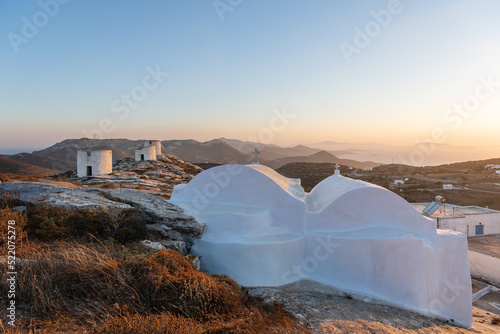 A whitewashed greek church and the traditional windmills of Chora, on Amorgos island in Greece.
