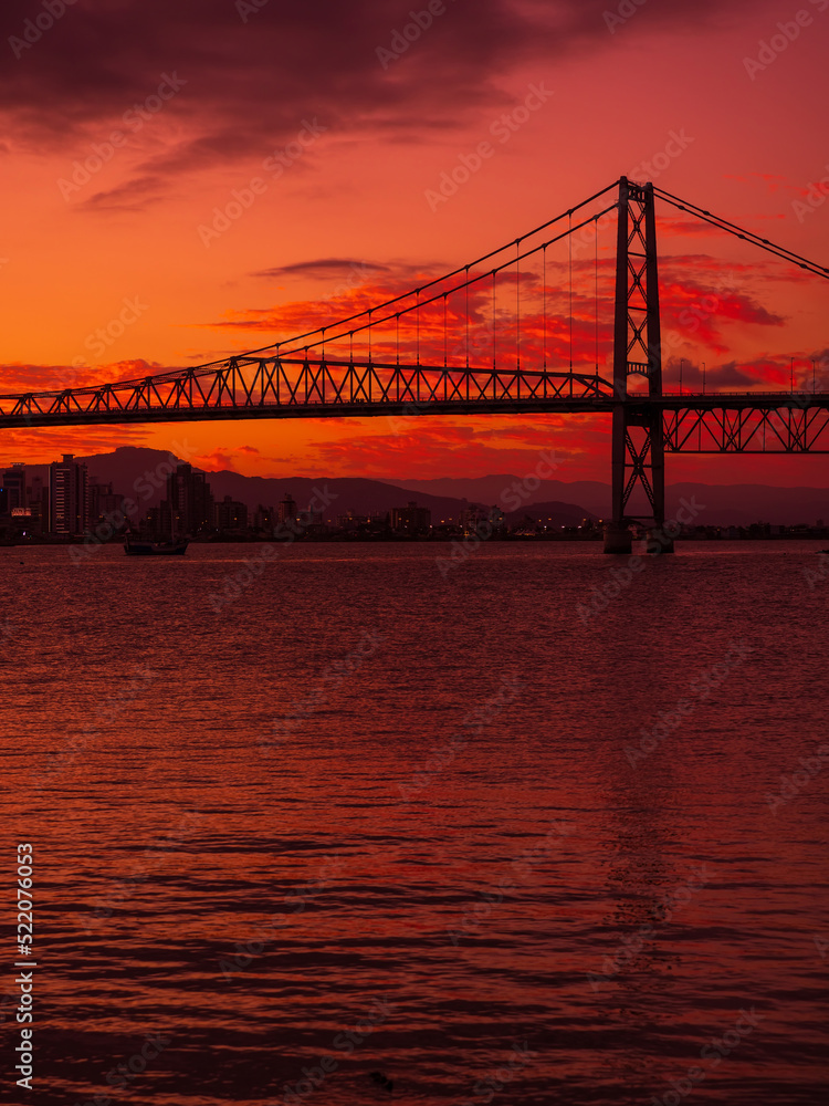 Hercilio luz cable bridge with sunset and reflection on water in Florianopolis