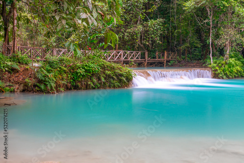 Magical turquoise blue colours of Kuang Si waterfalls Luang Prabang Laos. these waterfalls in the Mountains of Luang Prabang Laos flow all year round in the natural national park rainforest 