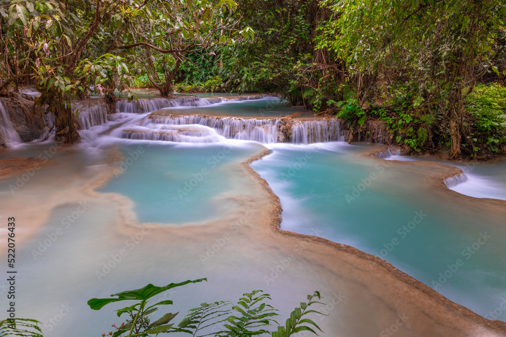 Obraz premium Magical turquoise blue colours of Kuang Si waterfalls Luang Prabang Laos. these waterfalls in the Mountains of Luang Prabang Laos flow all year round in the natural national park rainforest 