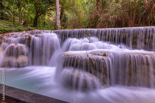 Fototapeta Naklejka Na Ścianę i Meble -  Magical turquoise blue colours of Kuang Si waterfalls Luang Prabang Laos. these waterfalls in the Mountains of Luang Prabang Laos flow all year round in the natural national park rainforest 