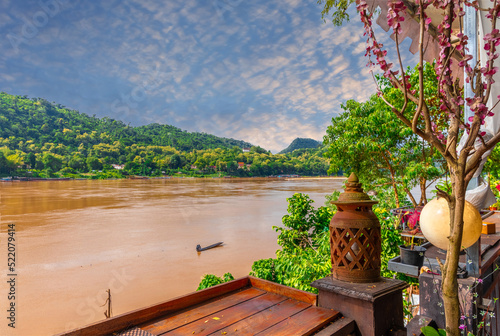 Luang Prabang Laos, beautiful river surrounded by lush green mountains and lovely historical houses