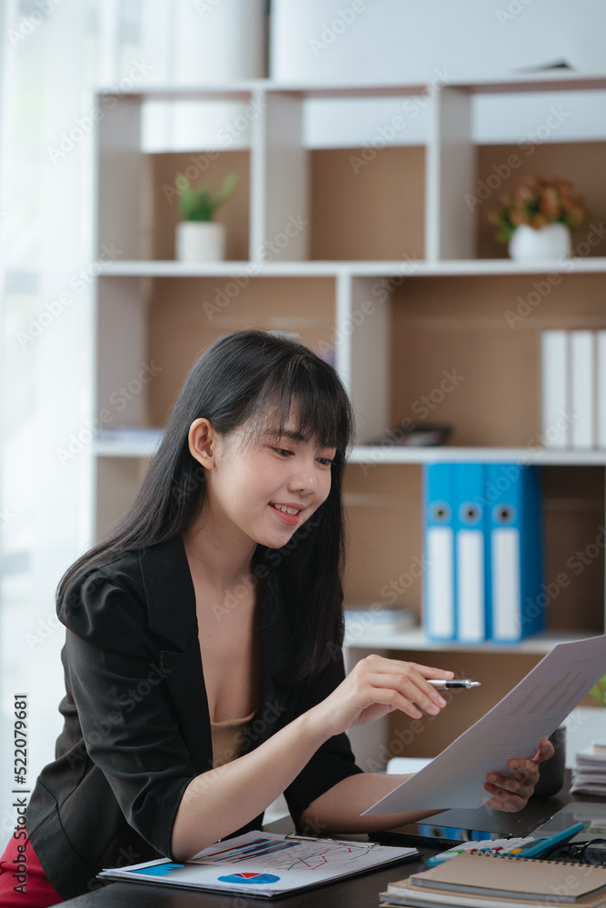 Young business woman is working and learning on paperworks and laptop in office space. Young business woman is working and learning on paperworks and laptop in office space.