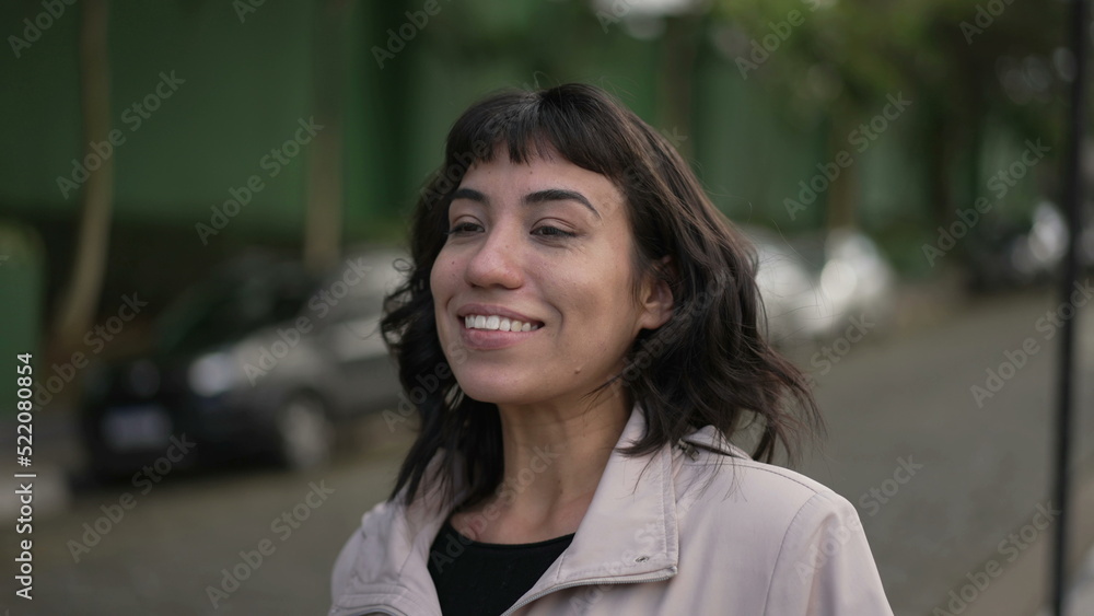 Happy woman walking outside. A carefree hispanic latin girl walks forward feeling joy wearing jacket Happy woman walking outside. A carefree hispanic latin girl walks forward feeling joy wearing jacket