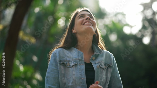 Φωτογραφία Happy woman standing at park looking at sky smiling