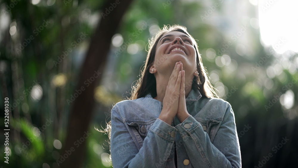 Happy woman being thankful. Spiritual girl praying looking at SKY with HOPE Happy woman being thankful. Spiritual girl praying looking at SKY with HOPE