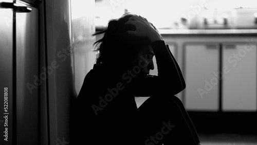 Fotografia Person suffering from mental illness sitting on floor at home in monochrome