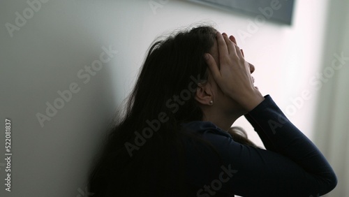 Person suffering from emotional pain leaning on wall sitting on floor. during desperate difficult times. Stress woman thinking of problems