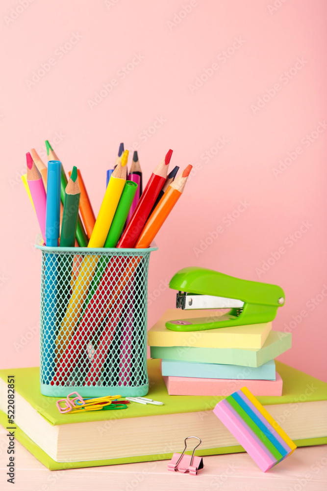 Fototapeta premium School accessories with books on pink background. Back to school concept. Vertical photo