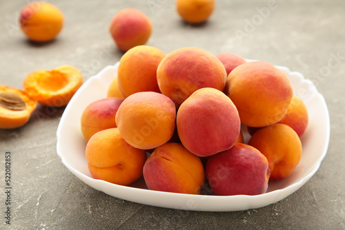 Fresh apricots in the bowl on grey concrete background