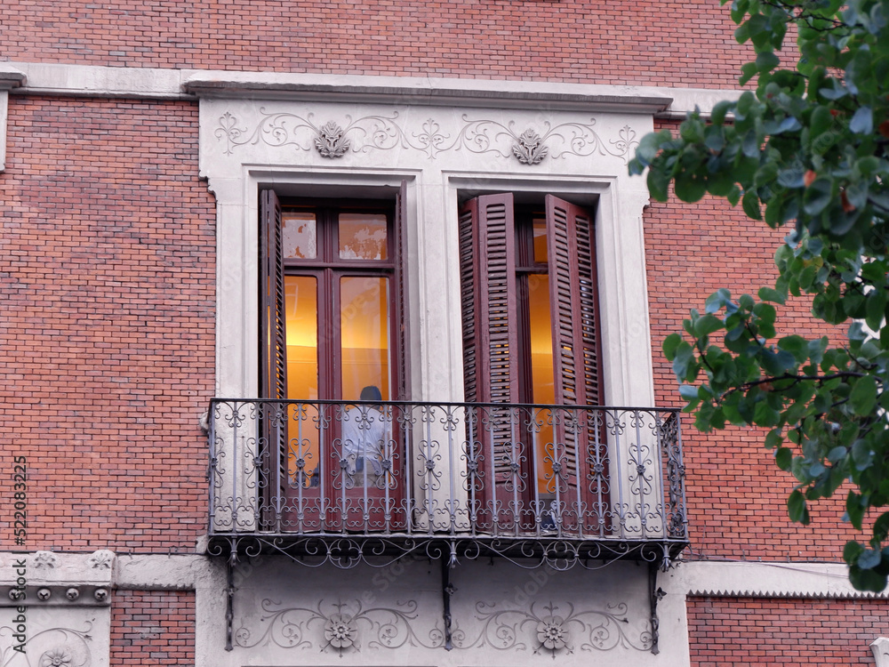 Close up on classical balcony with double doors and shutters downtown Madrid in Chueca district, Spain