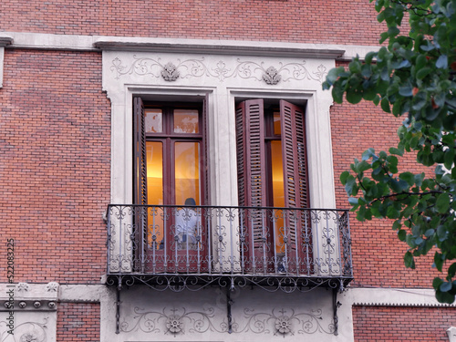 Close up on classical balcony with double doors and shutters downtown Madrid in Chueca district, Spain