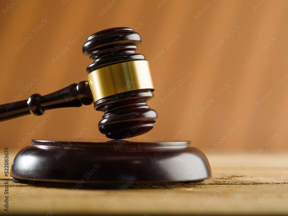 Close-up. On a wooden table is a judge's gavel on a beige background. Minimalism. Judgment and justice, auction. There are no people in the photo. There is free space to insert. Banner. Close-up. On a wooden table is a judge's gavel on a beige background. Minimalism. Judgment and justice, auction. There are no people in the photo. There is free space to insert. Banner.