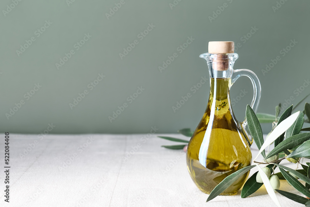 Extra virgin olive oil and olive branch in the bottle on the table with linen tablecloth. Healthy mediterranean food. Extra virgin olive oil and olive branch in the bottle on the table with linen tablecloth. Healthy mediterranean food.
