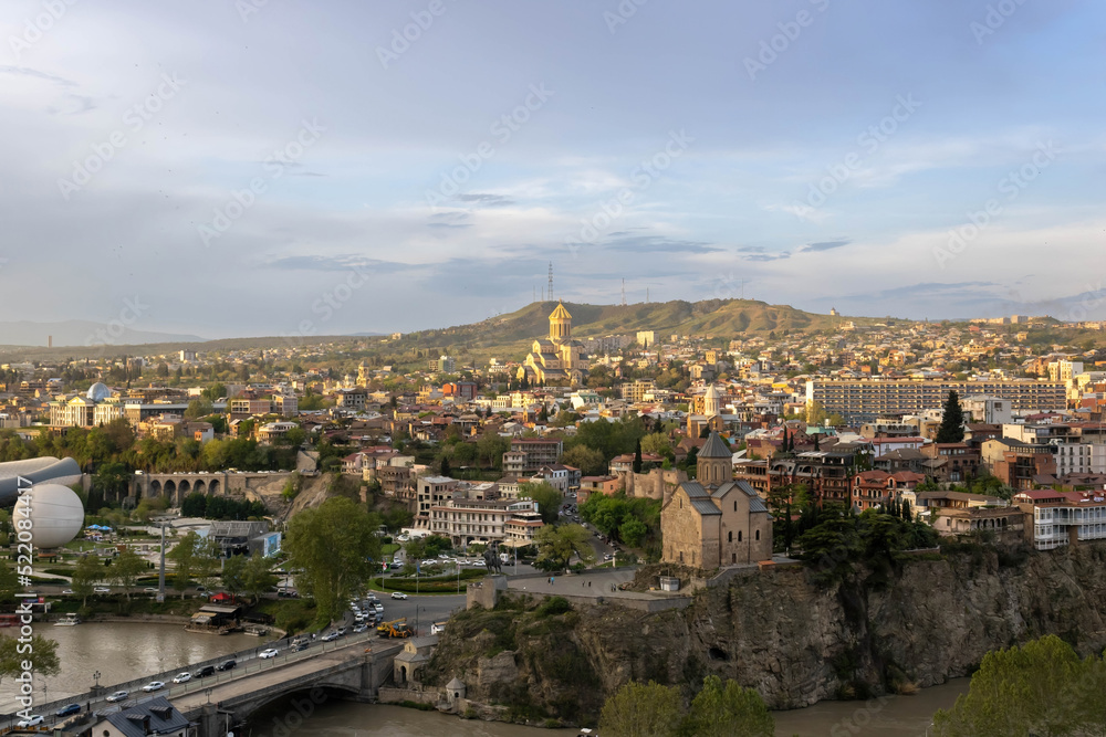 A panoramic aerial view of Tbilisi historic center from the Narikala Fortress at a sunset
