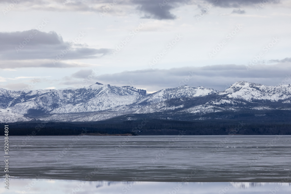 View of a frozen Yellowstone Lake with snow covered mountains in American Landscape. Yellowstone National Park. United States. Nature Background.