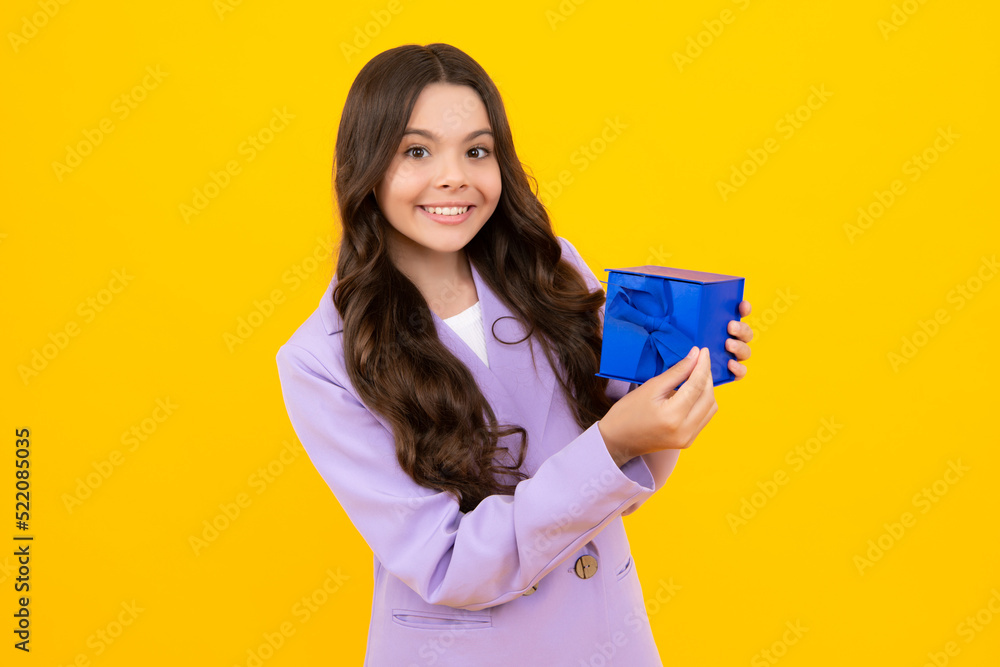 Happy teenager, positive and smiling emotions of teen girl. Child with gift present box on isolated studio background. Gifting for kids birthday. Happy teenager, positive and smiling emotions of teen girl. Child with gift present box on isolated studio background. Gifting for kids birthday.