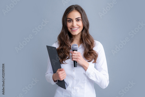 Young business woman talking with mic. Woman talking with microphone. Communication and information concept.