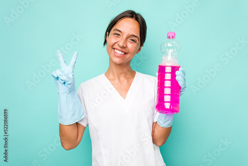 Young cleaner hispanic woman isolated on blue background showing number two with fingers.