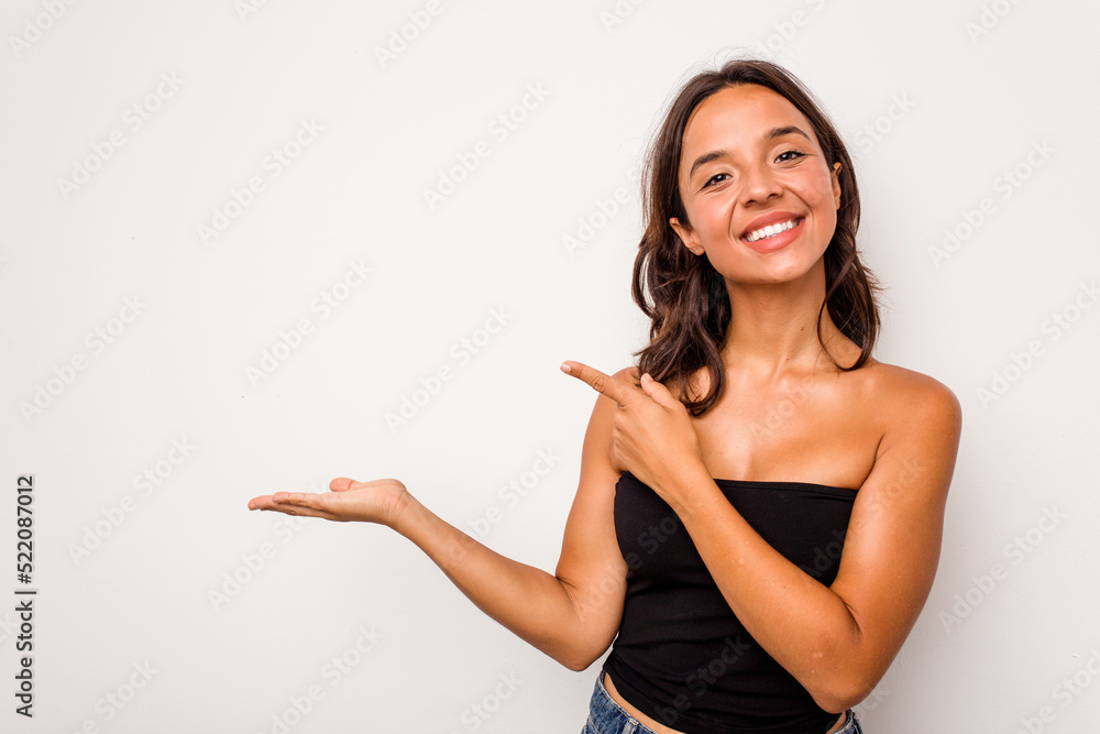 Young hispanic woman isolated on white background excited holding a copy space on palm. Young hispanic woman isolated on white background excited holding a copy space on palm.