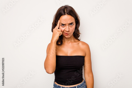 Young hispanic woman isolated on white background pointing temple with finger, thinking, focused on a task.