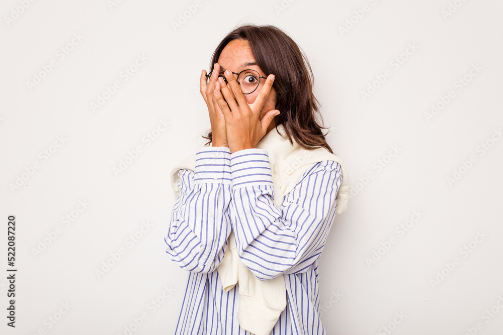 Young hispanic woman isolated on white background blink through fingers frightened and nervous. Young hispanic woman isolated on white background blink through fingers frightened and nervous.