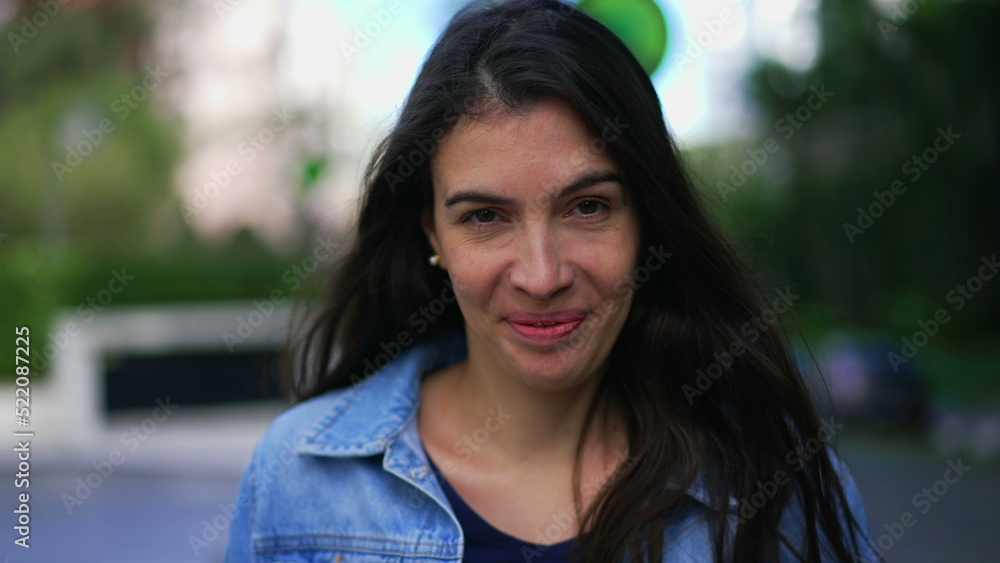 Confident happy woman walking forward in street looking at camera. Person in 30s portrait face closeup walks in sidewalk Confident happy woman walking forward in street looking at camera. Person in 30s portrait face closeup walks in sidewalk