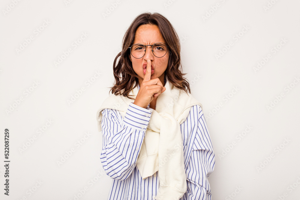 Young hispanic woman isolated on white background keeping a secret or asking for silence. Young hispanic woman isolated on white background keeping a secret or asking for silence.