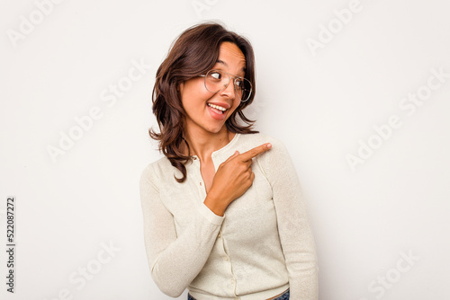Young hispanic woman isolated on white background looks aside smiling, cheerful and pleasant.