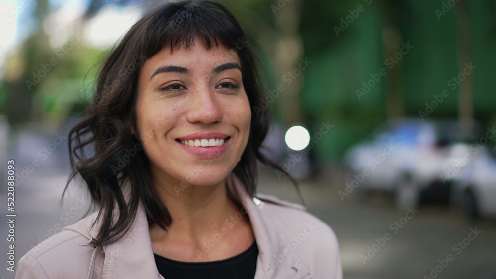 A happy Brazilian young woman walking forward smiling face closeup