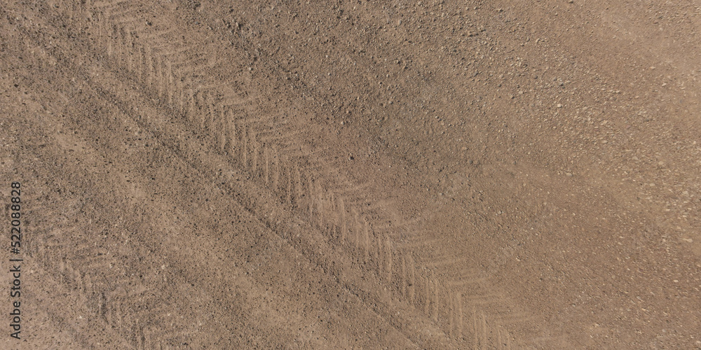 panorama of surface from above of gravel road with car tire tracks panorama of surface from above of gravel road with car tire tracks