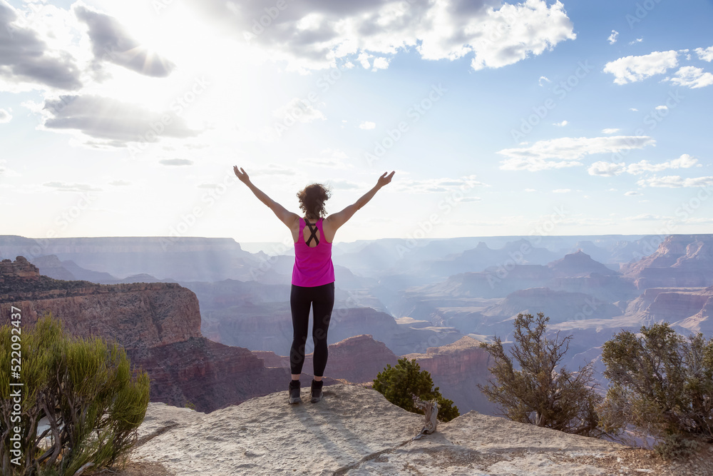 Adventurous Traveler standing on Desert Rocky Mountain American Landscape. Cloudy Sunny Sky. Grand Canyon National Park, Arizona, United States. Adventure Travel Adventurous Traveler standing on Desert Rocky Mountain American Landscape. Cloudy Sunny Sky. Grand Canyon National Park, Arizona, United States. Adventure Travel